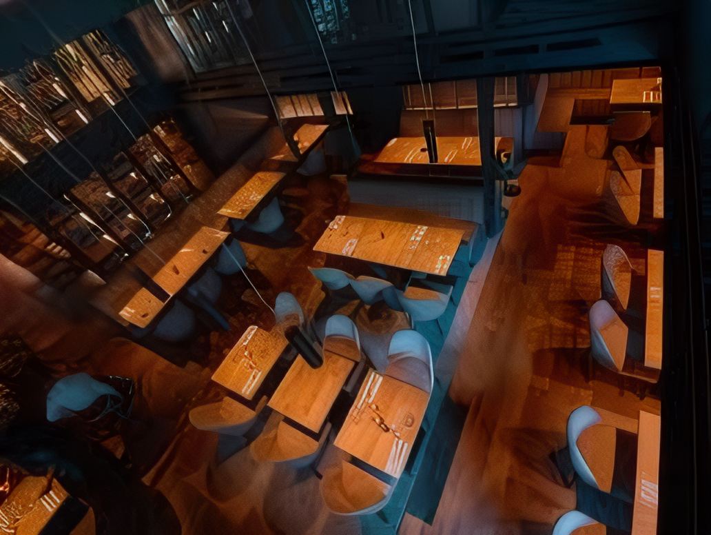 La salle vue de la mezzanine, tables et fauteuils sous les suspensions